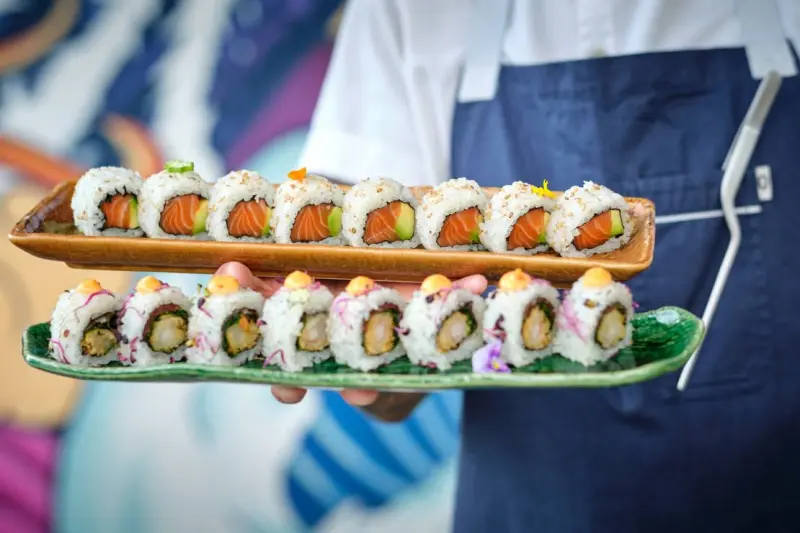 chef holding trays with delicious sushi rolls